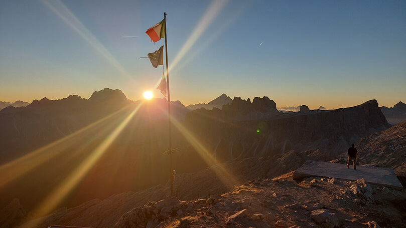 Dolomiten Berggipfel mit Fahnen bei Sonnenuntergang